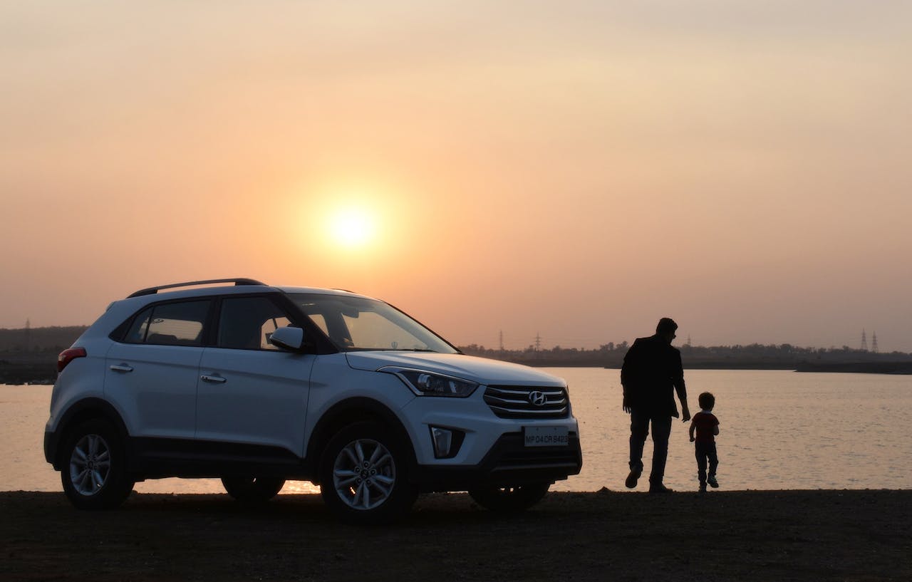 Services A touching silhouette of a father and son beside a car at sunset by a lake in Bhopal, India.