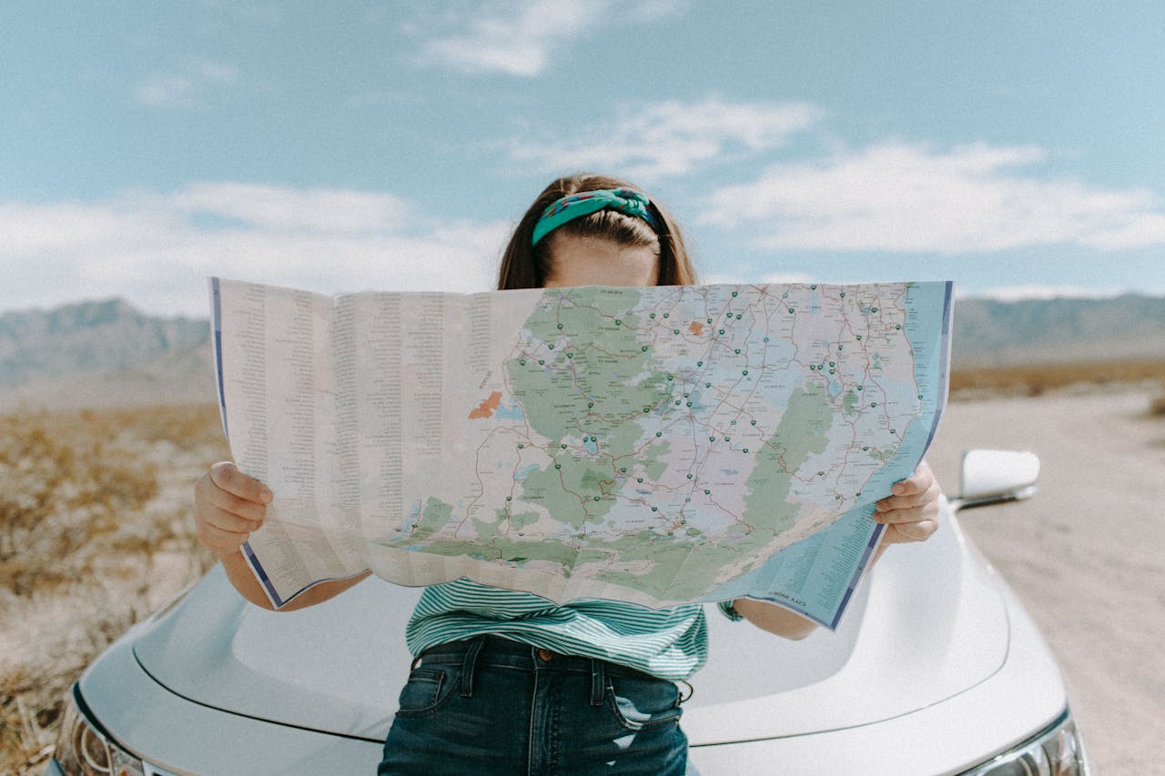 About A woman holds a map while traveling through the scenic desert of California, USA.