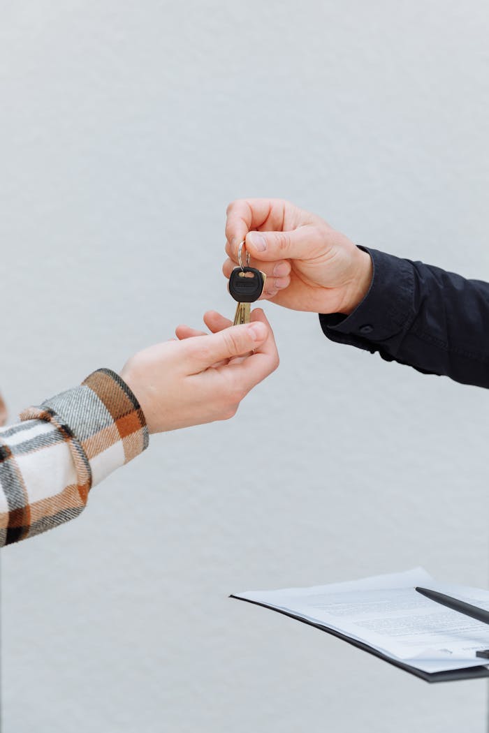 About Close-up of hands exchanging car keys, symbolizing a business transaction.